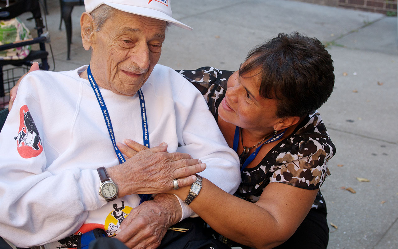 Certified Home Health Agent from the New Jewish Home caring for an older gentleman outside in a wheelchair