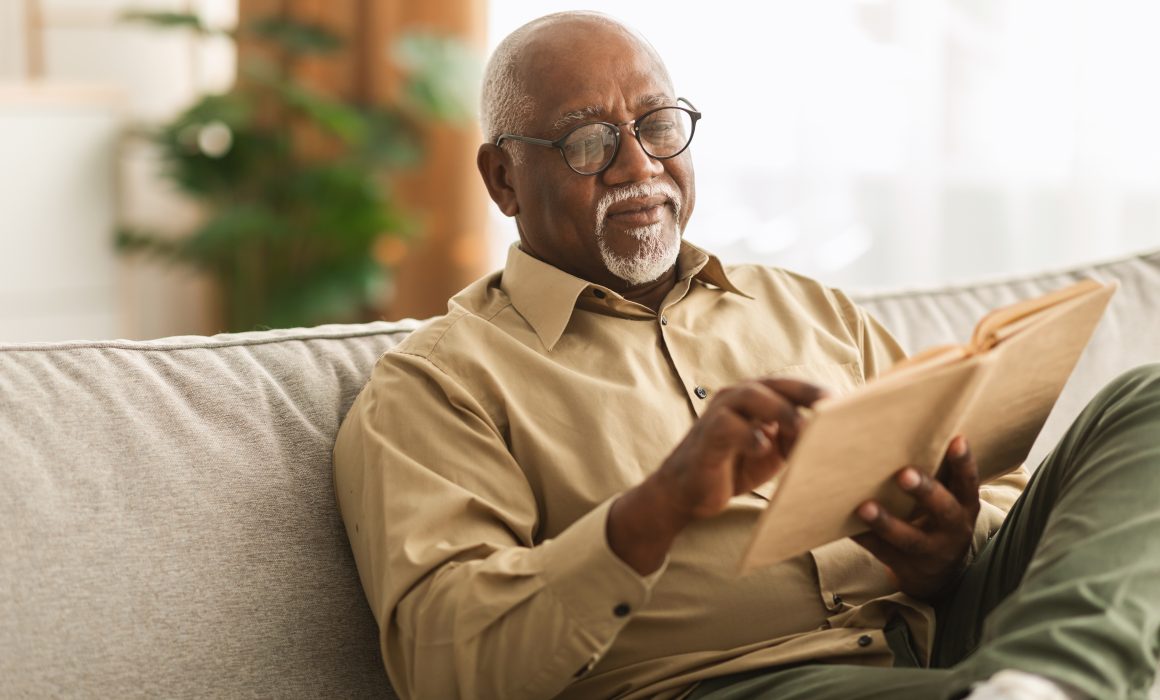 senior man reading on couch